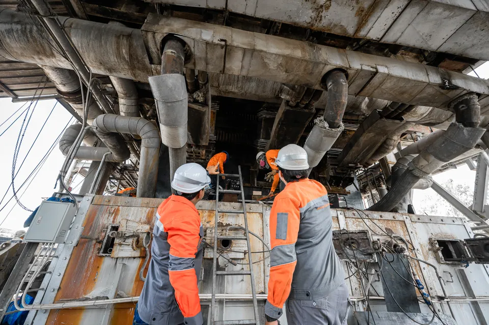 Engineers inspecting boiler casing and ducting from below